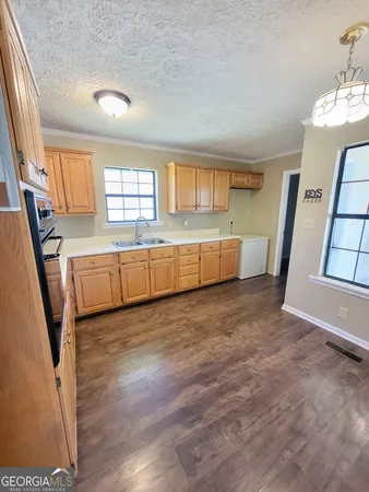 a view of a big room with wooden floor and windows