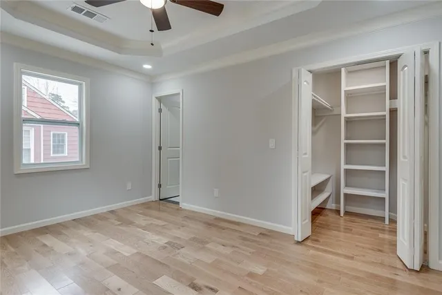 a view of empty room with wooden floor and window