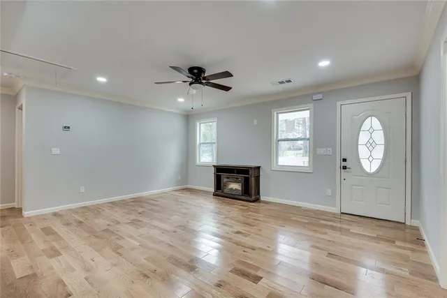an empty room with wooden floor and windows