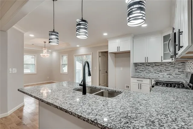a kitchen with kitchen island granite countertop a sink a center island and stainless steel appliances