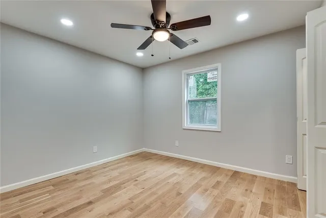an empty room with a window and a fan