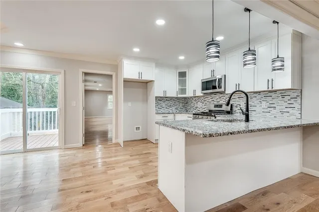 a kitchen with stainless steel appliances granite countertop a sink a refrigerator and a stove