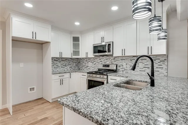 a kitchen with stainless steel appliances granite countertop a sink stove and refrigerator