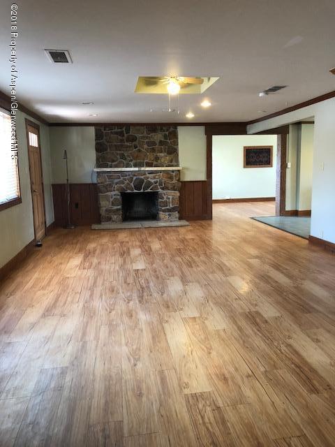 455 West 3rd Street Rifle, CO 81650 - Photo 2 of 16 an empty room with wooden floor and kitchen view