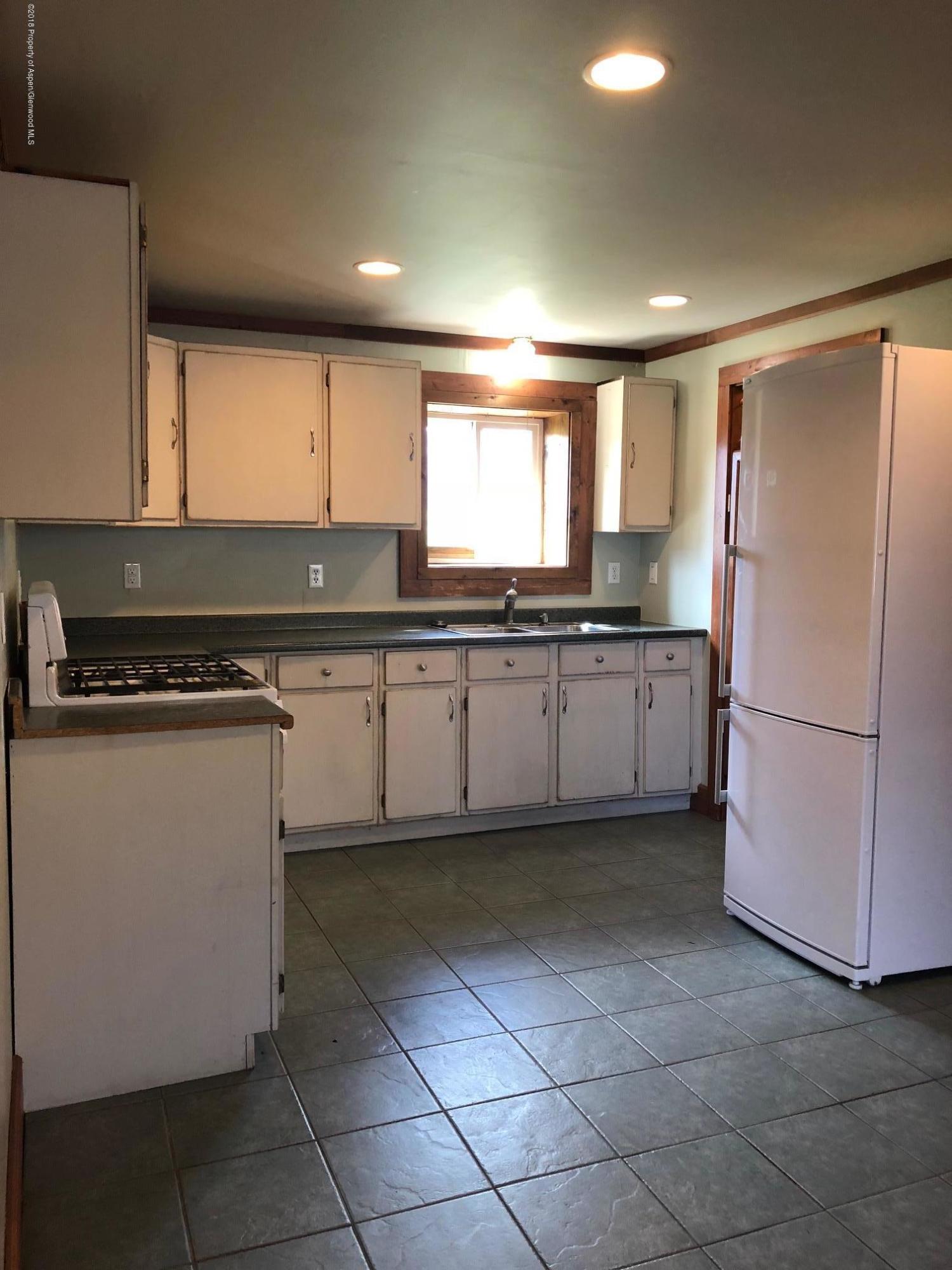 455 West 3rd Street Rifle, CO 81650 - Photo 3 of 16 a kitchen with stainless steel appliances granite countertop a refrigerator and a stove top oven