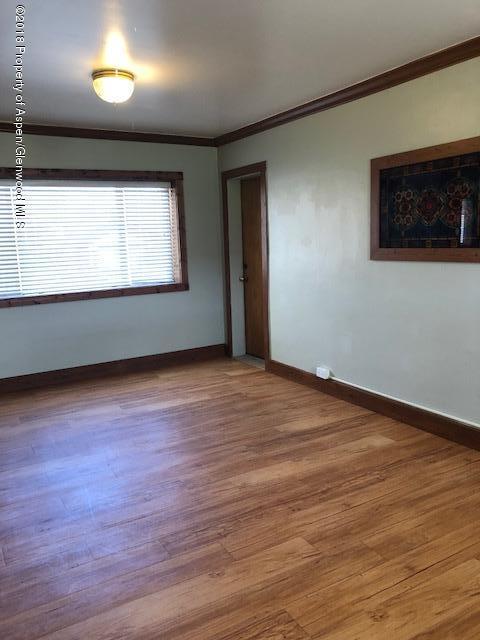 455 West 3rd Street Rifle, CO 81650 - Photo 6 of 16 an empty room with wooden floor and windows