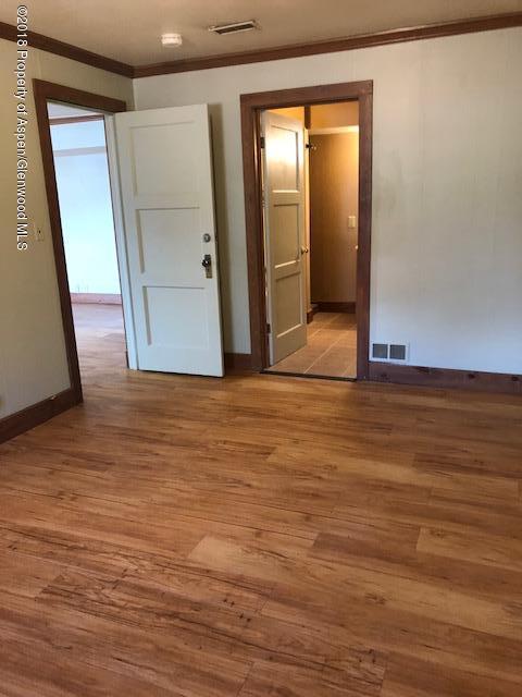 455 West 3rd Street Rifle, CO 81650 - Photo 8 of 16 a view of an empty room with wooden floor and a mirror