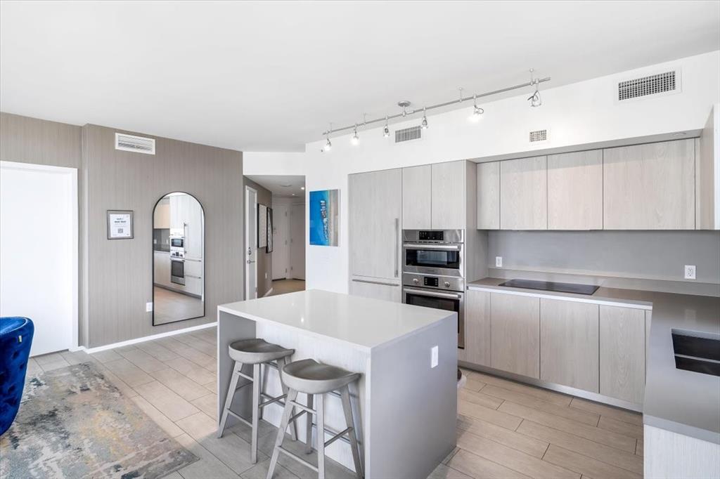 4010 South Ocean Drive, Unit R1102 Hollywood, FL 33019 - Photo 18 of 47 a kitchen with stainless steel appliances a sink a stove a refrigerator cabinets and a dining table