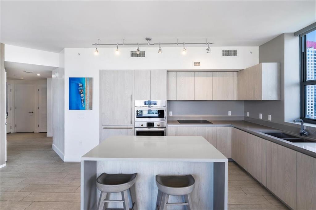 4010 South Ocean Drive, Unit R1102 Hollywood, FL 33019 - Photo 19 of 47 a kitchen with a table chairs stove and cabinets