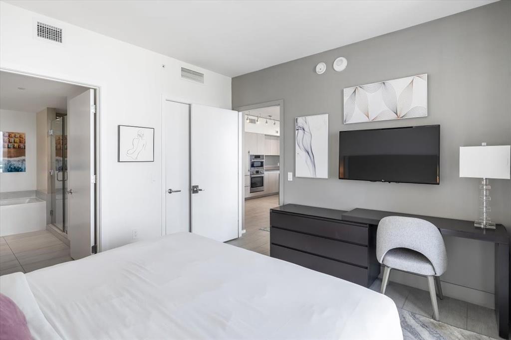 4010 South Ocean Drive, Unit R1102 Hollywood, FL 33019 - Photo 23 of 47 a bedroom with a bed and a flat screen tv