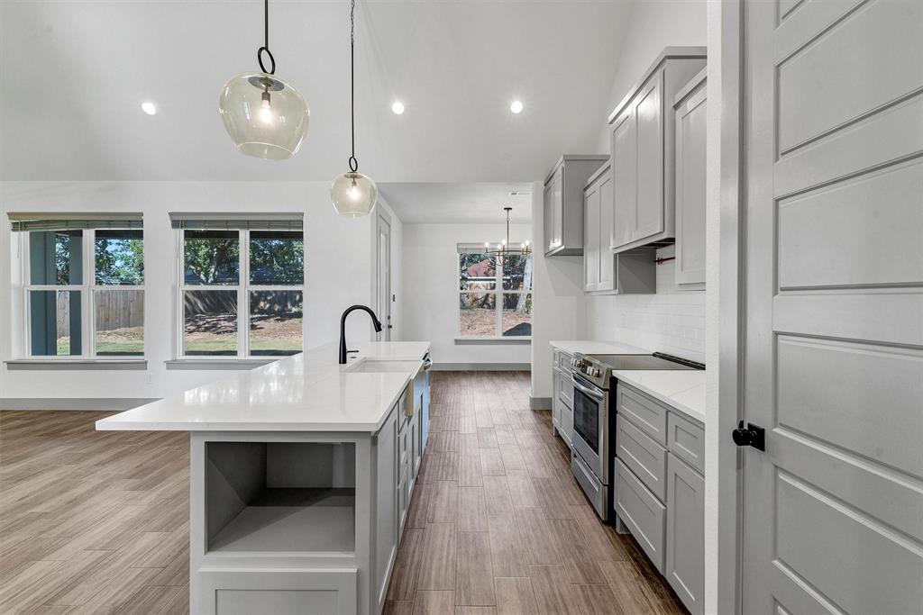 2029 Rattler Way Tolar, TX 76476 - Photo 12 of 28 a kitchen with kitchen island a counter top space a sink stainless steel appliances and cabinets