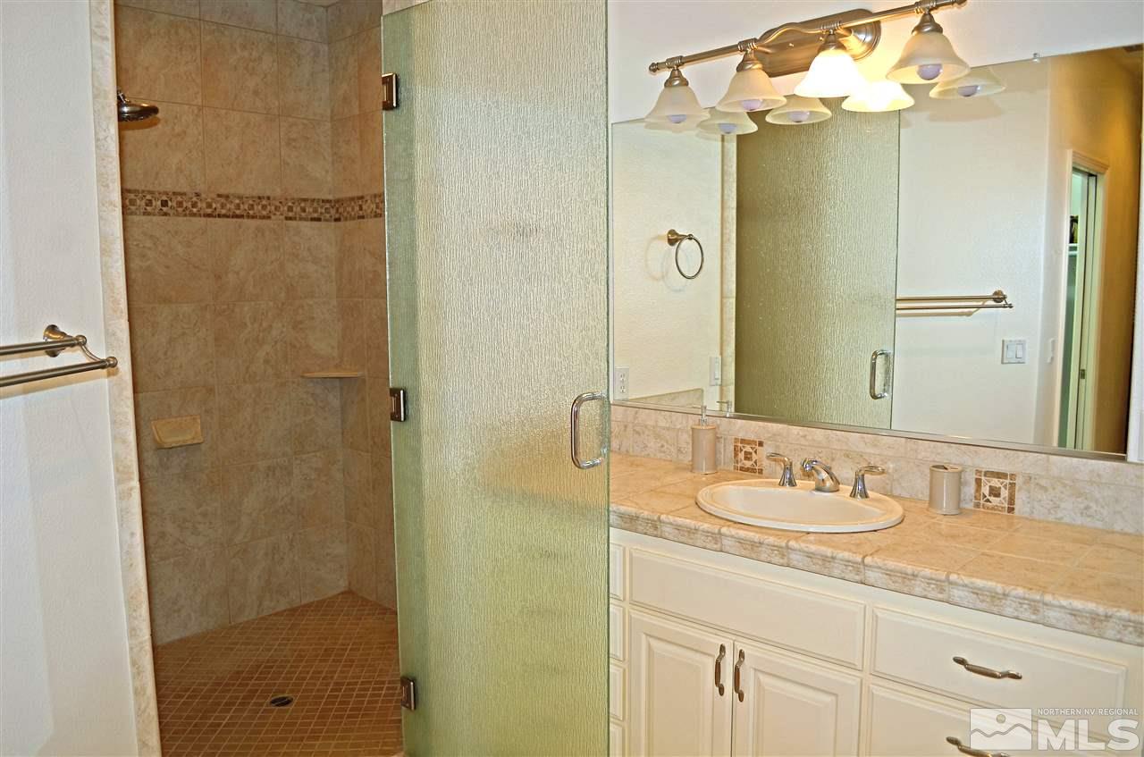 5100 Wayside Road Reno, NV 89510 - Photo 11 of 25 a bathroom with a granite countertop shower sink vanity and mirror