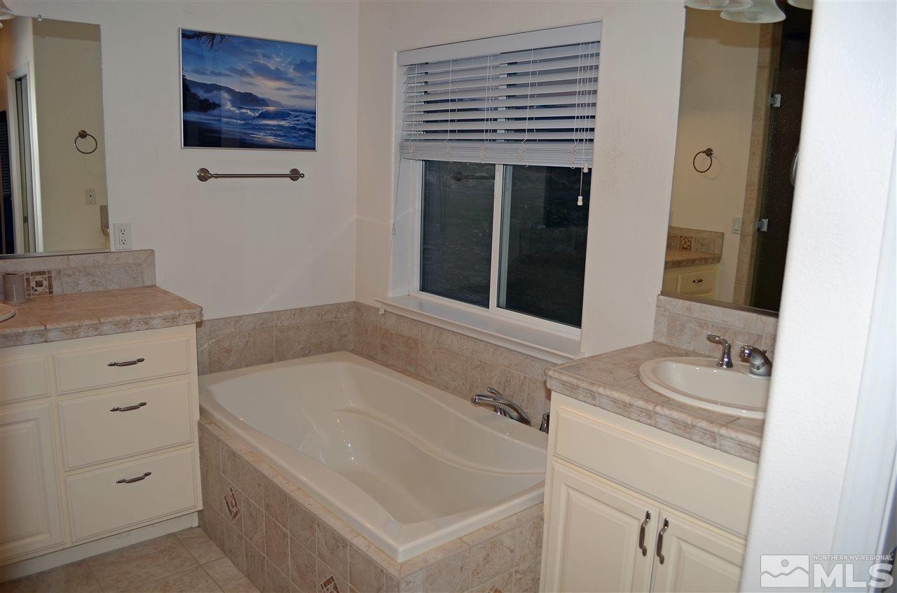 5100 Wayside Road Reno, NV 89510 - Photo 12 of 25 a bathroom with a tub sink and mirror
