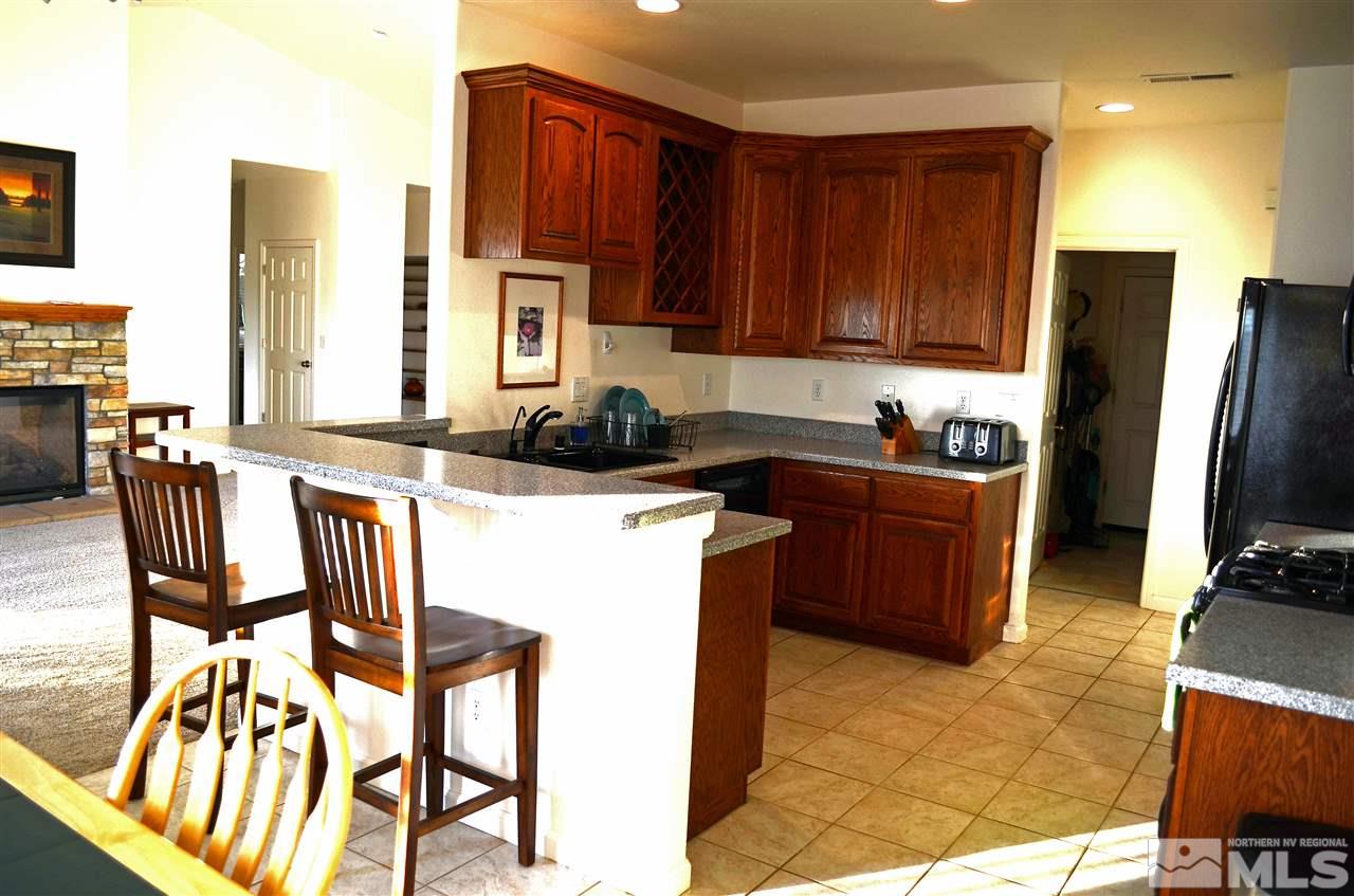 5100 Wayside Road Reno, NV 89510 - Photo 7 of 25 a kitchen with stainless steel appliances granite countertop a sink a stove a refrigerator cabinets and dining table
