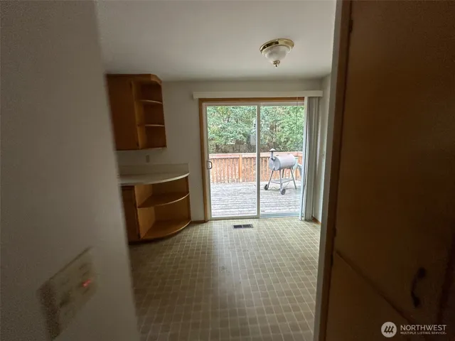 a view of an empty room with a fireplace and a window