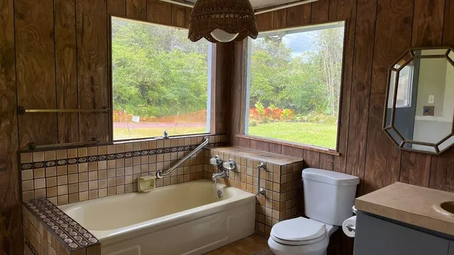 a bathroom with a sink a toilet a window and bathtub