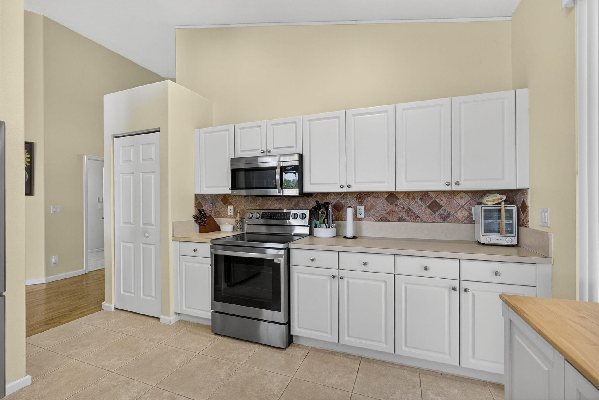 11061 Laurel Walk Road Wellington, FL 33449 - Photo 19 of 67 a kitchen with white cabinets and stainless steel appliances