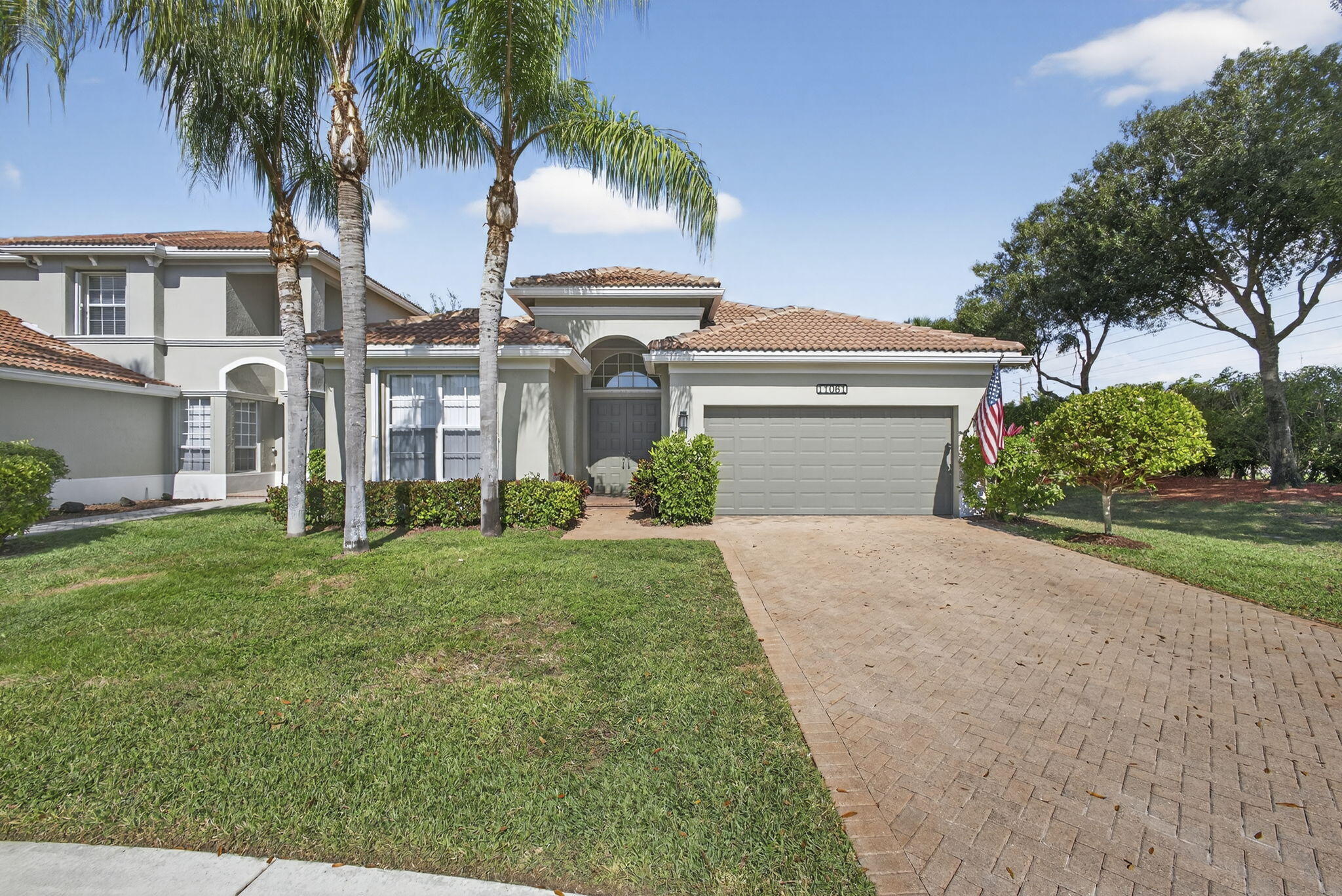 11061 Laurel Walk Road Wellington, FL 33449 - Photo 3 of 67 a front view of a house with a garden and yard