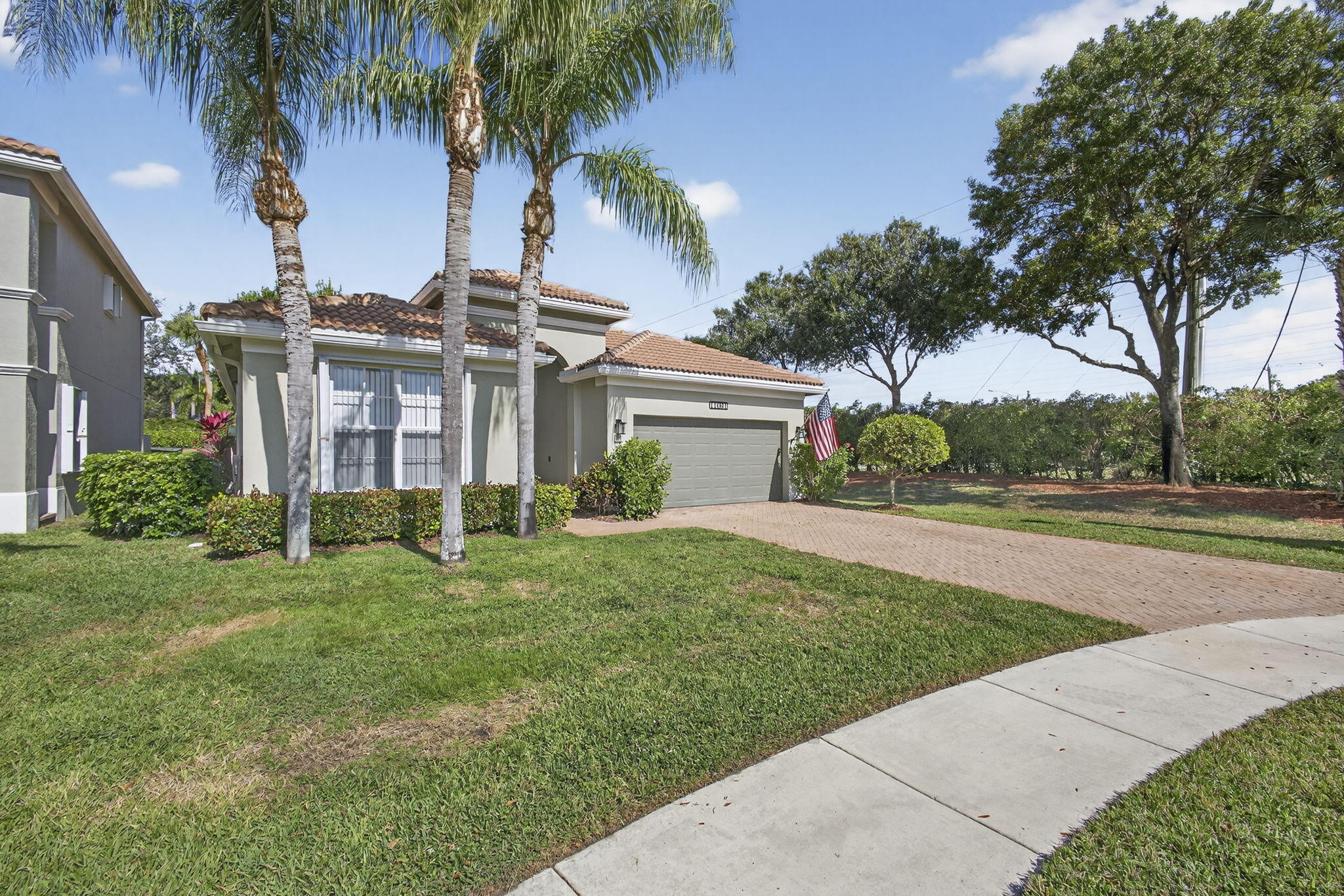 11061 Laurel Walk Road Wellington, FL 33449 - Photo 4 of 67 a front view of a house with a yard and palm trees