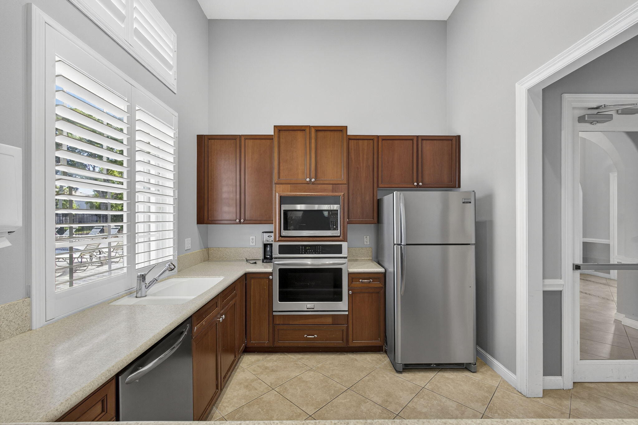 11061 Laurel Walk Road Wellington, FL 33449 - Photo 66 of 67 a kitchen with kitchen island a counter top space stainless steel appliances and a window
