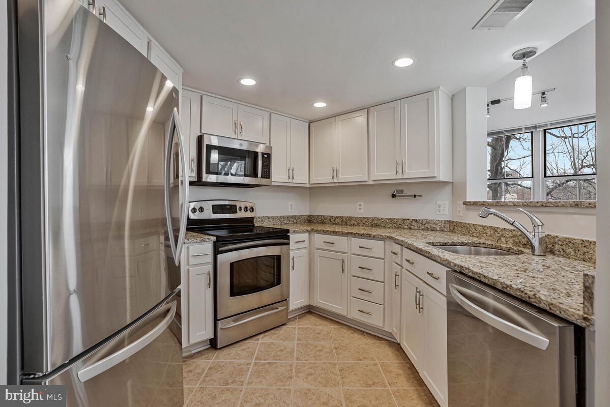 11800 Sunset Hills Road, Unit 514 Reston, VA 20190 - Photo 25 of 57 a kitchen with granite countertop a sink stove and refrigerator