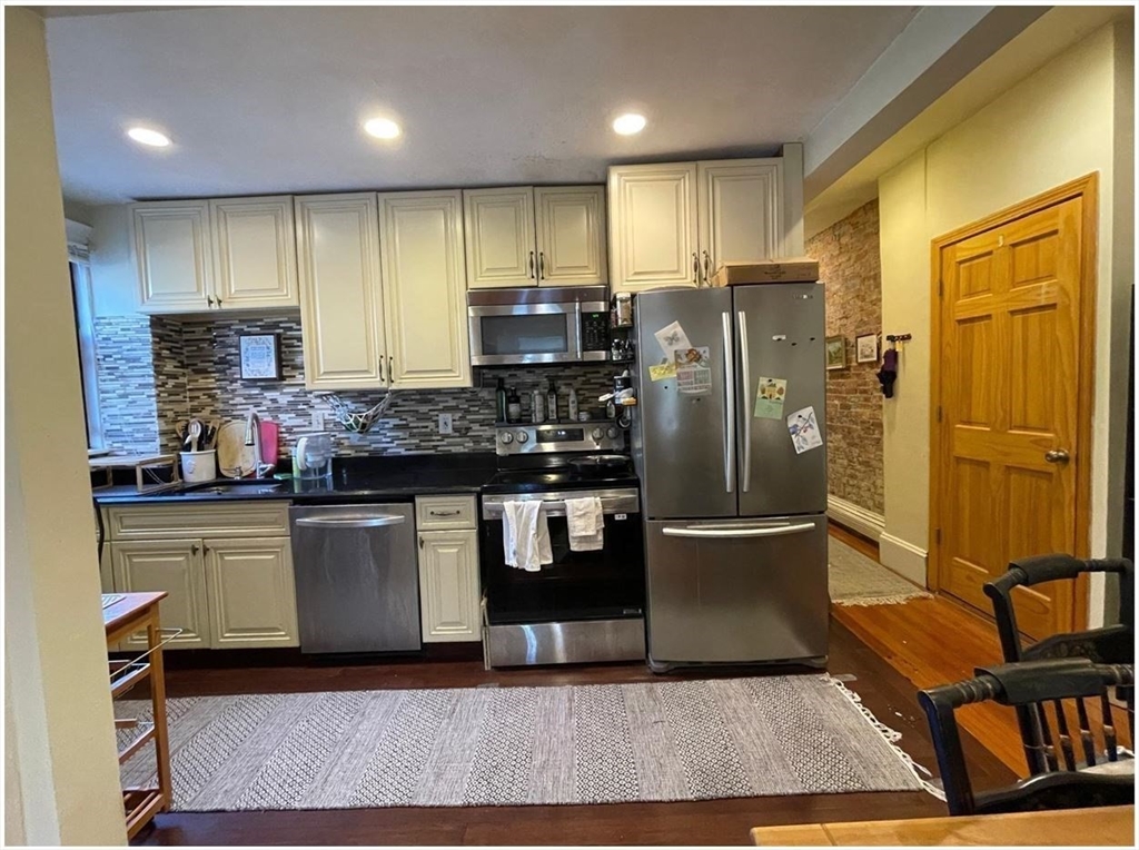 a kitchen with stainless steel appliances granite countertop a refrigerator and a stove