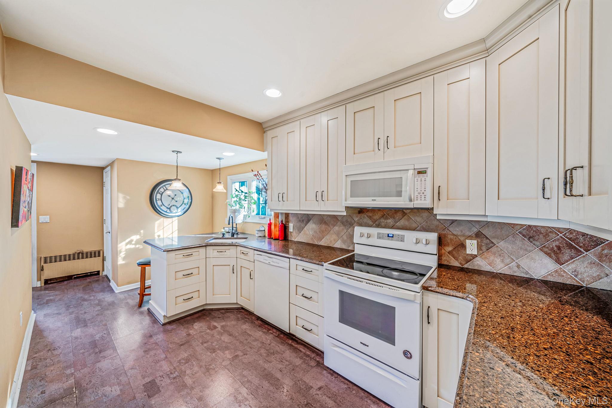 59 Robertson Road Lynbrook, NY 11563 - Photo 12 of 26 a kitchen with granite countertop white cabinets and white appliances