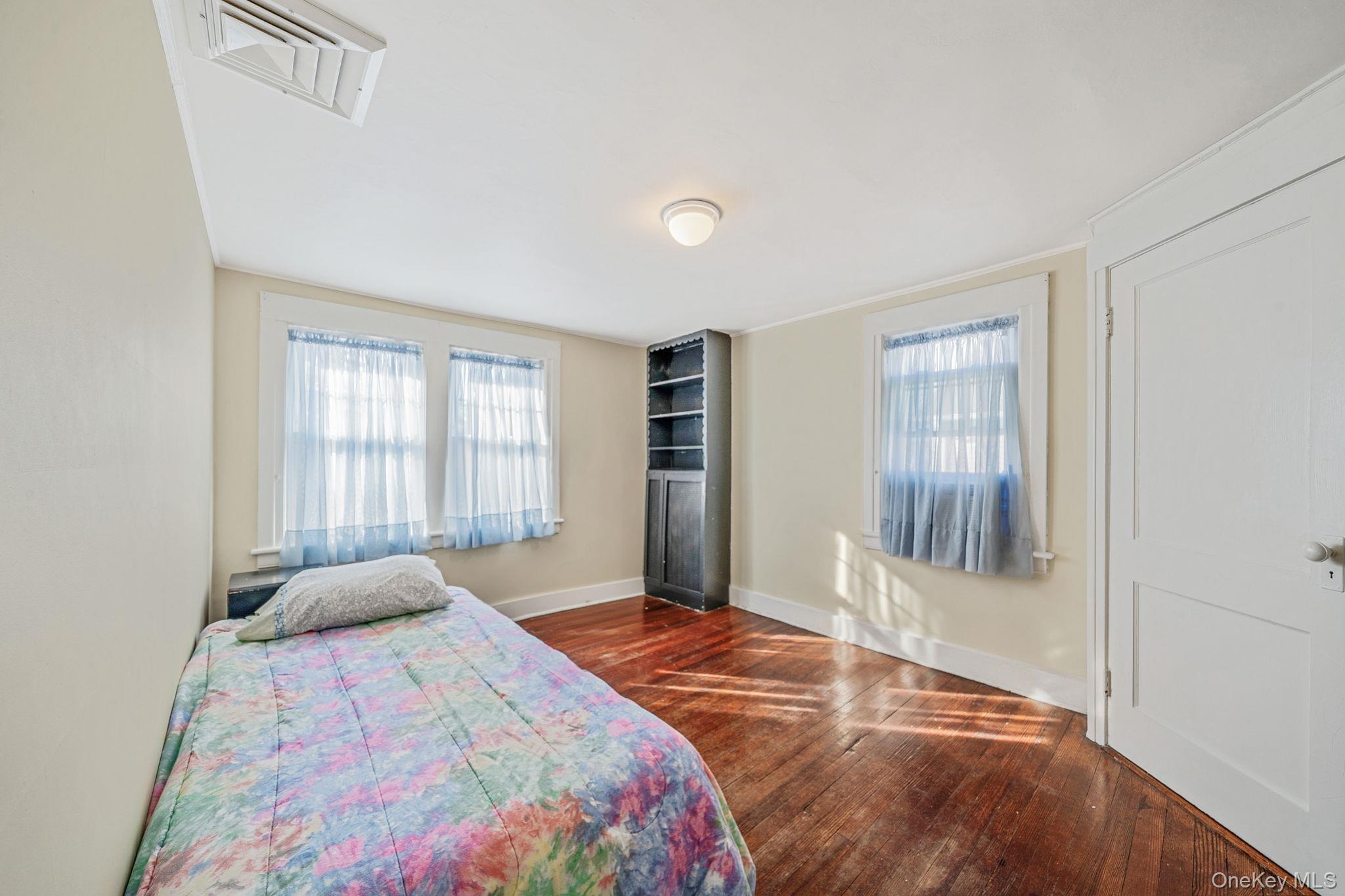 59 Robertson Road Lynbrook, NY 11563 - Photo 18 of 26 a bedroom with a large bed and wooden floor