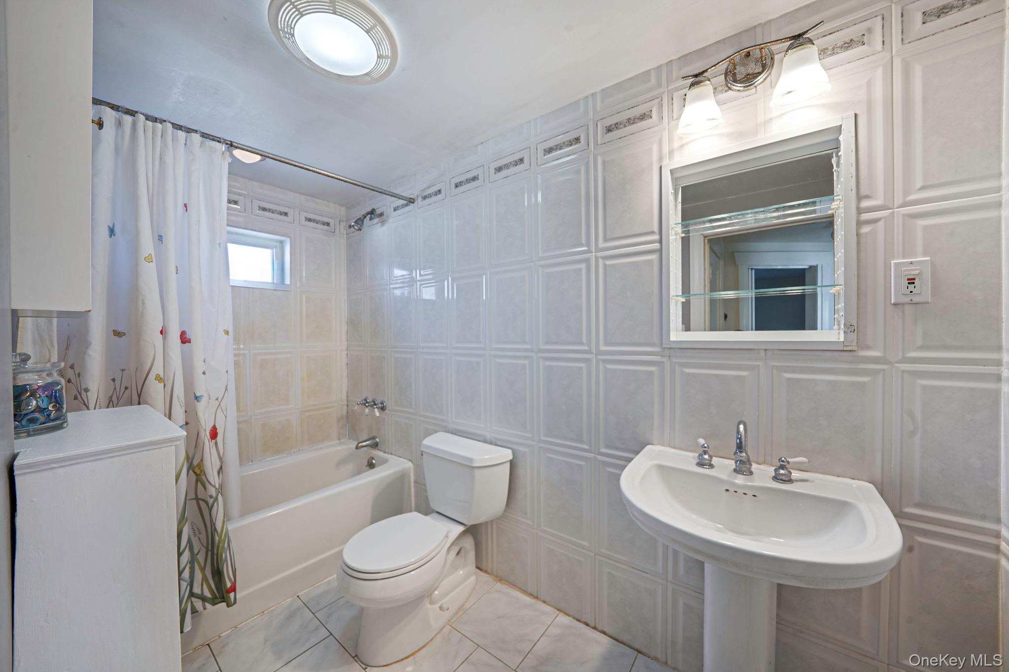 59 Robertson Road Lynbrook, NY 11563 - Photo 19 of 26 a bathroom with a sink toilet tub and shower