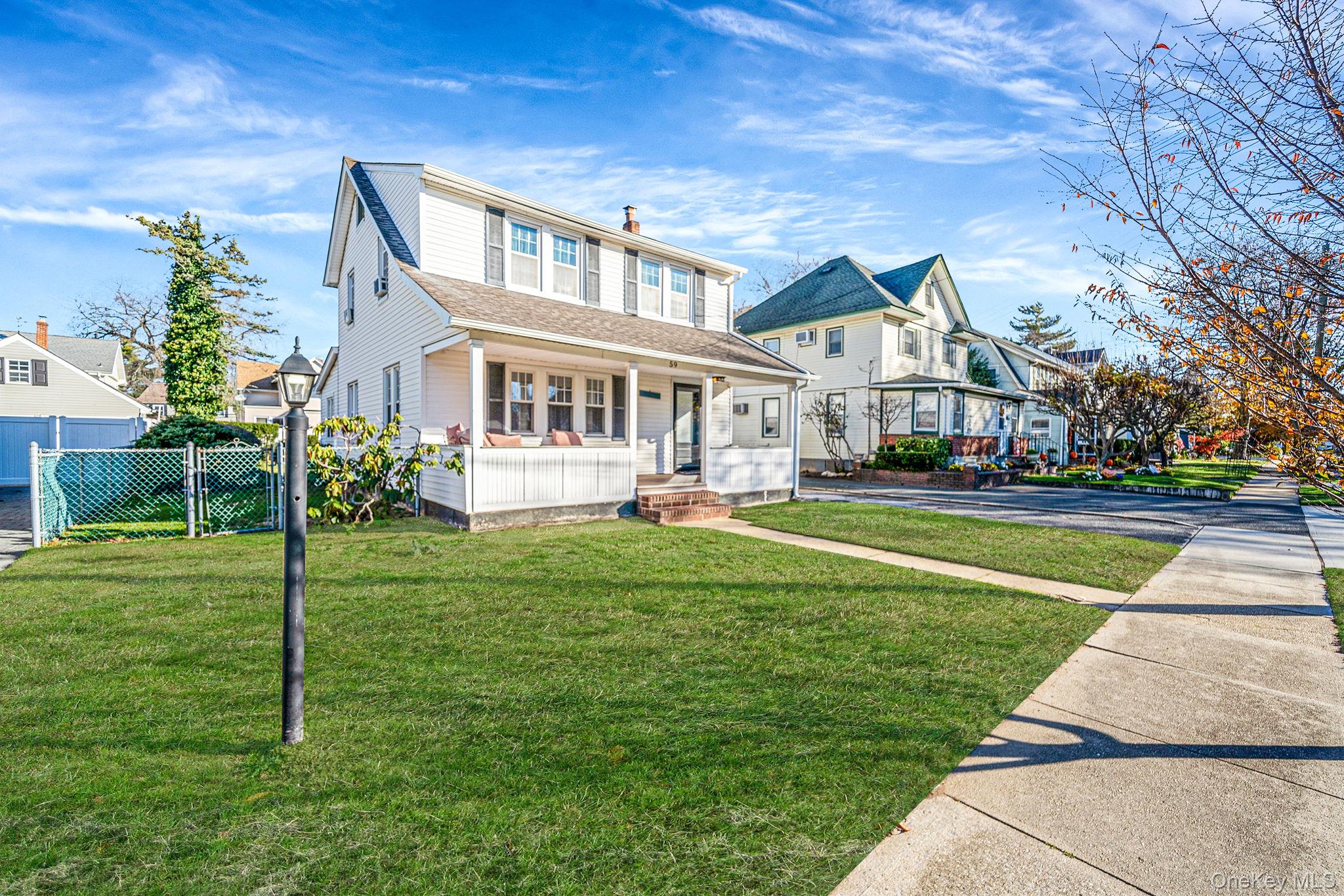 59 Robertson Road Lynbrook, NY 11563 - Photo 2 of 26 a front view of house with yard and green space