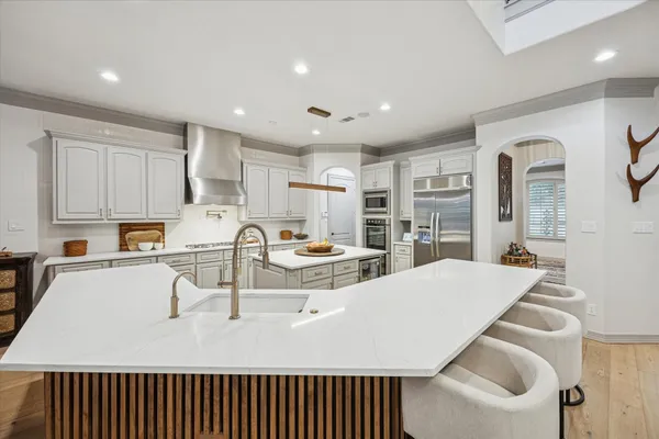 a large kitchen with kitchen island a stove a sink a refrigerator and cabinets