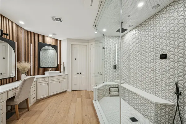 a bathroom with a double vanity sink a mirror and a bathtub