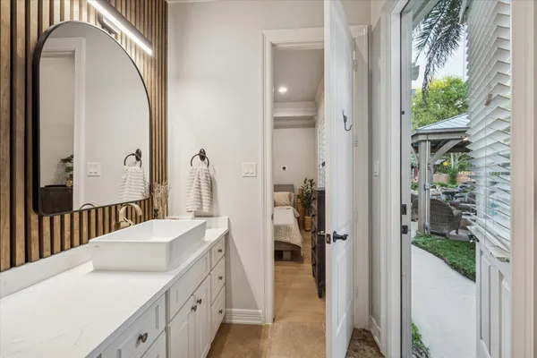 a en suite bathroom with a sink and mirror with bathtub