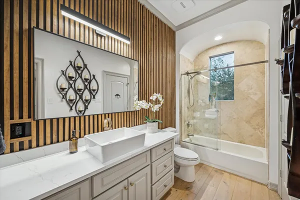 a bathroom with a granite countertop sink a toilet and shower