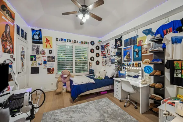 a bedroom with a workspace and a window