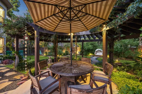 a view of a patio with a table chairs and a backyard