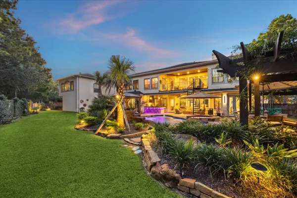 a view of a house with a yard and potted plants