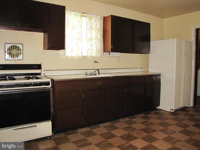 1832 Colmar Road Gwynn Oak, MD 21207 - Photo 4 of 12 a kitchen with a sink and a stove top oven
