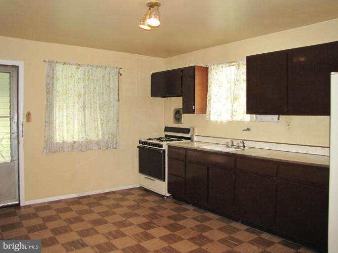 1832 Colmar Road Gwynn Oak, MD 21207 - Photo 5 of 12 a kitchen with a sink cabinets and appliances