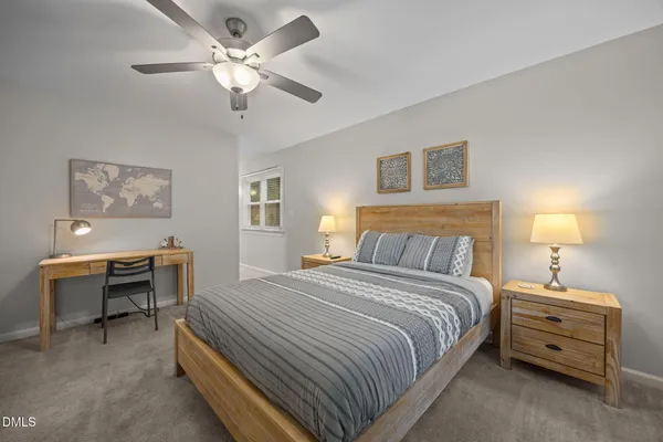 a bedroom with a large bed and a chandelier