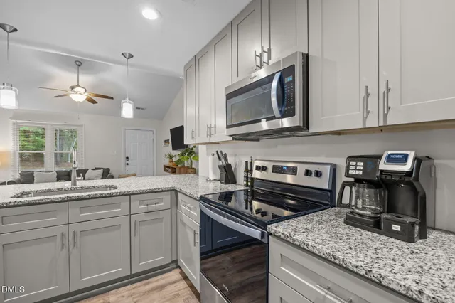 a kitchen with granite countertop a sink stainless steel appliances and cabinets