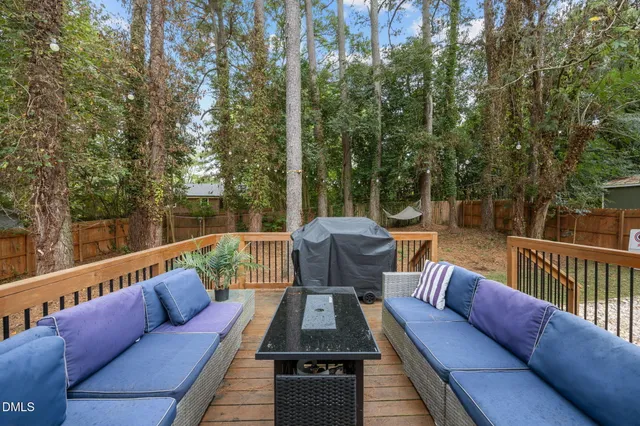 a roof deck with couches and wooden fence