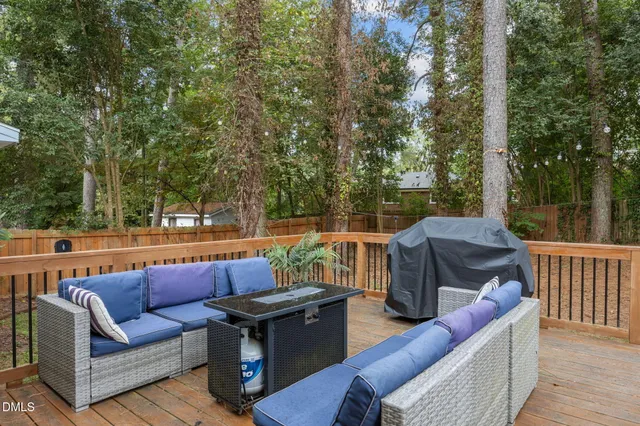 a view of house with wooden deck and a barbeque