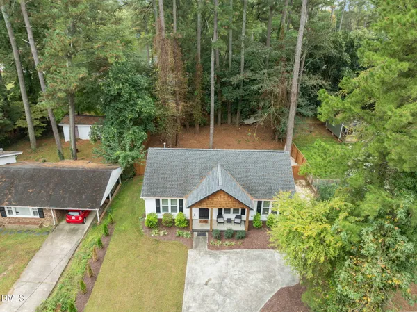 an aerial view of residential houses with outdoor space and trees