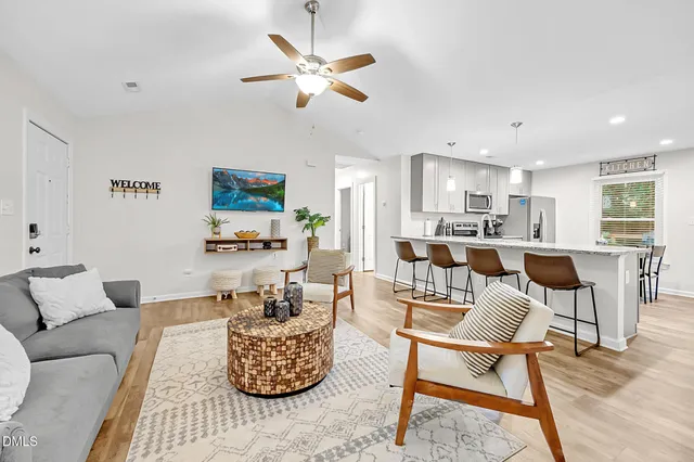 a living room with furniture and kitchen view