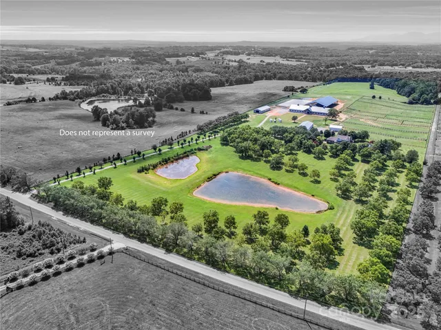 an aerial view of residential houses with outdoor space and trees