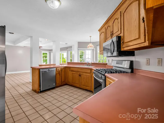 a kitchen with stainless steel appliances granite countertop a stove a sink and a microwave