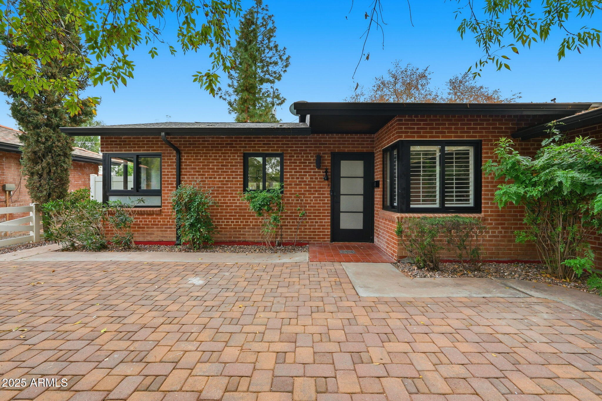 a front view of a house with a yard and potted plants