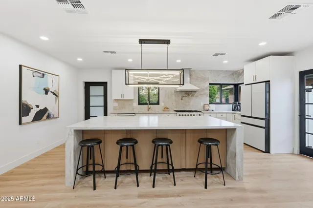 a large kitchen with kitchen island a large counter top space a sink stainless steel appliances and cabinets