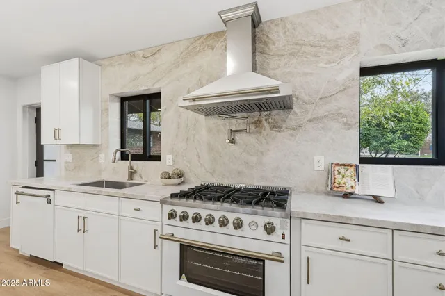 a large white kitchen with a large window